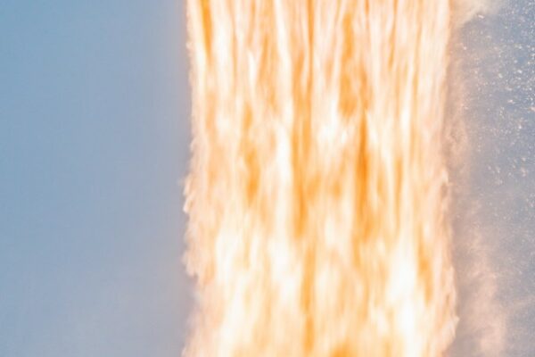 A SpaceX Falcon 9 rocket lifts off and leaves a trail of flames below.
