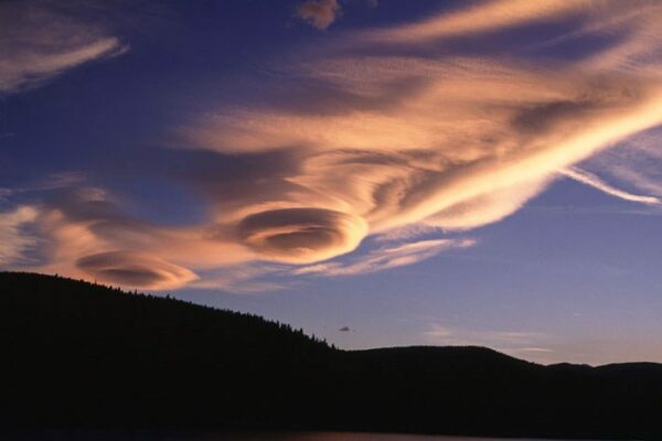 Lenticular Clouds at sunset over a mountain range