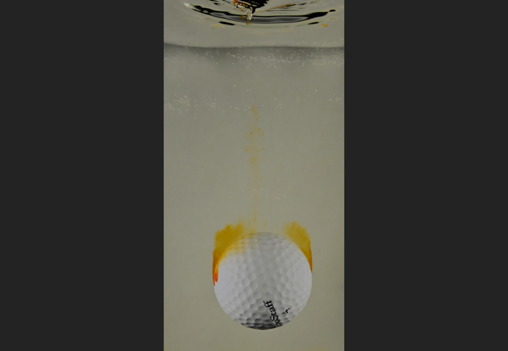 Golf ball falling in water tank