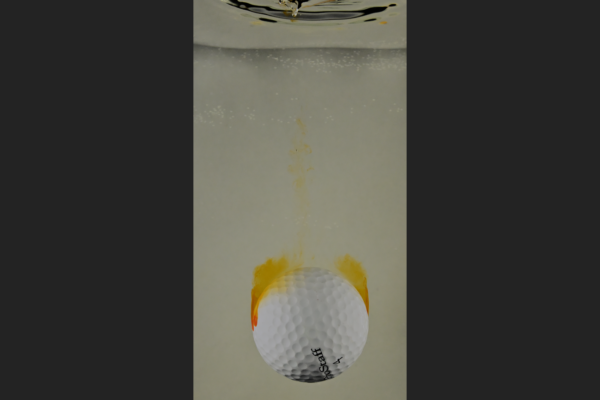 Golf ball falling in water tank